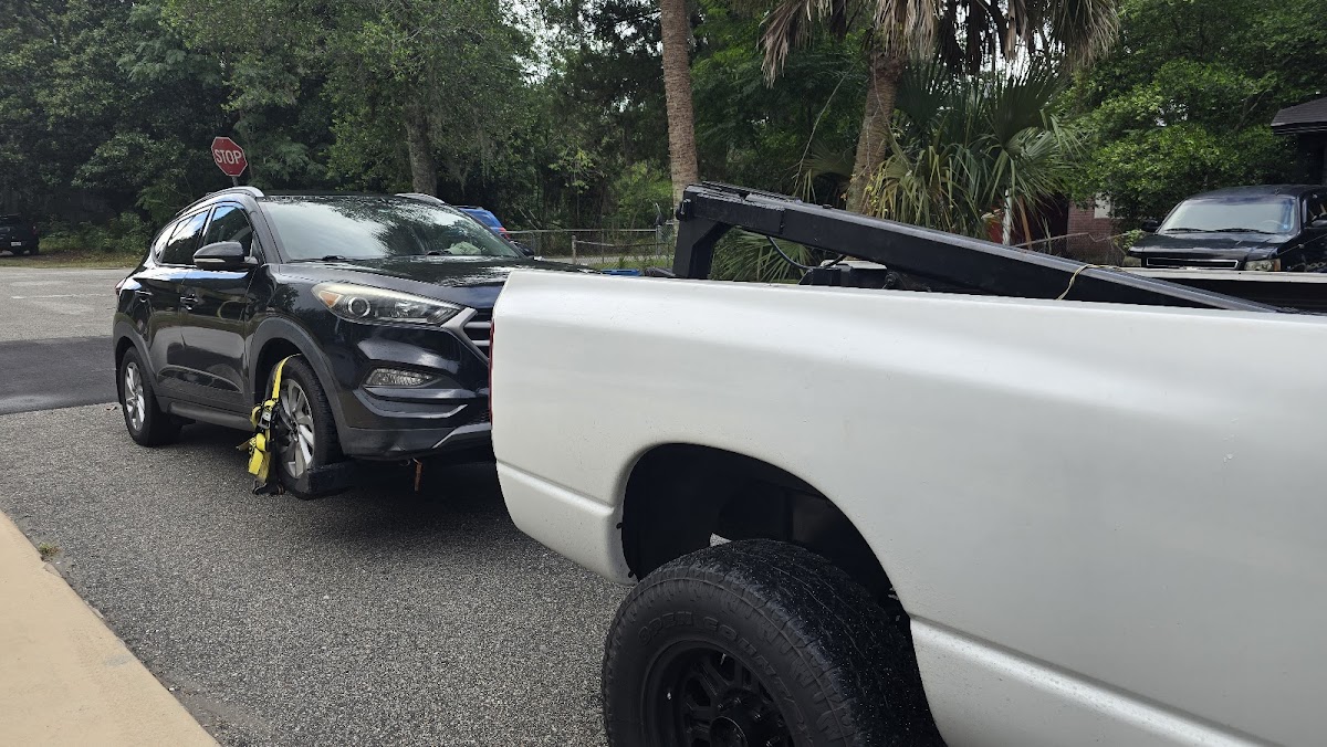 White wrecker hooking up a Hyundai Tucson SUV